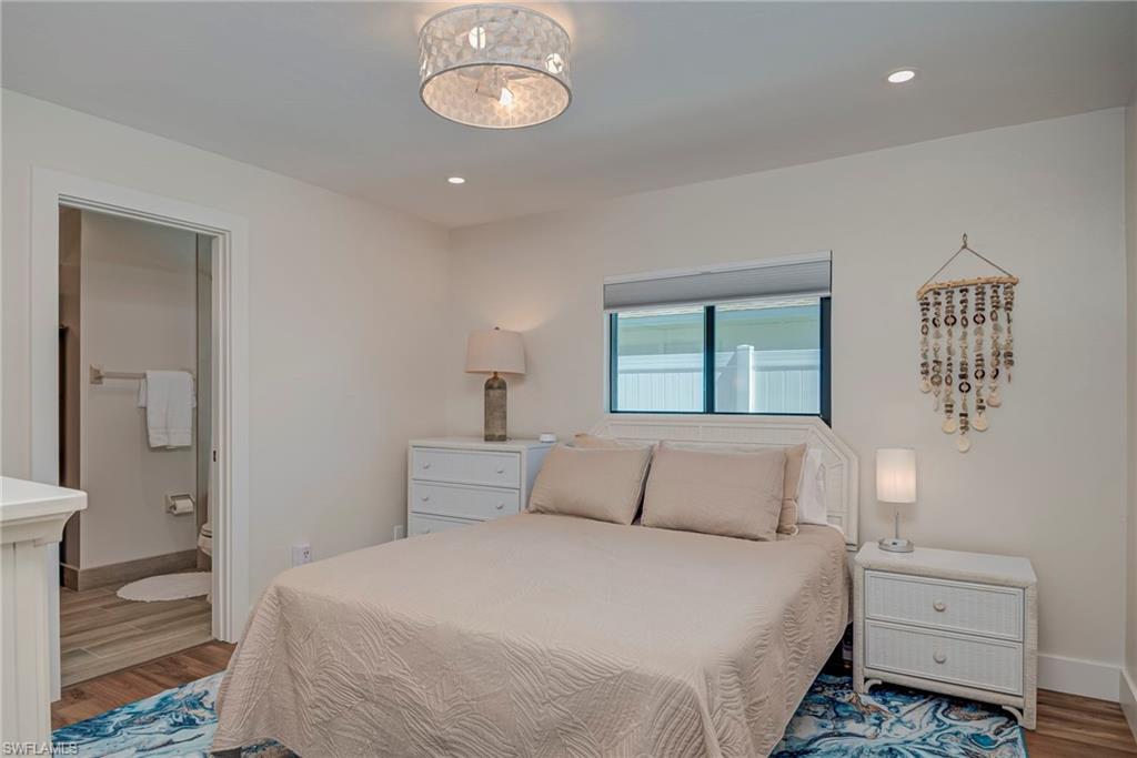 Bedroom featuring wood finished floors, recessed lighting, and ensuite bathroom