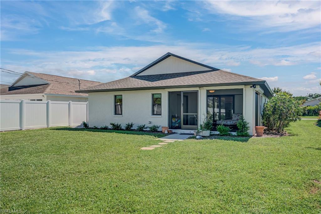Back of property with roof with shingles, a sunroom, and stucco siding