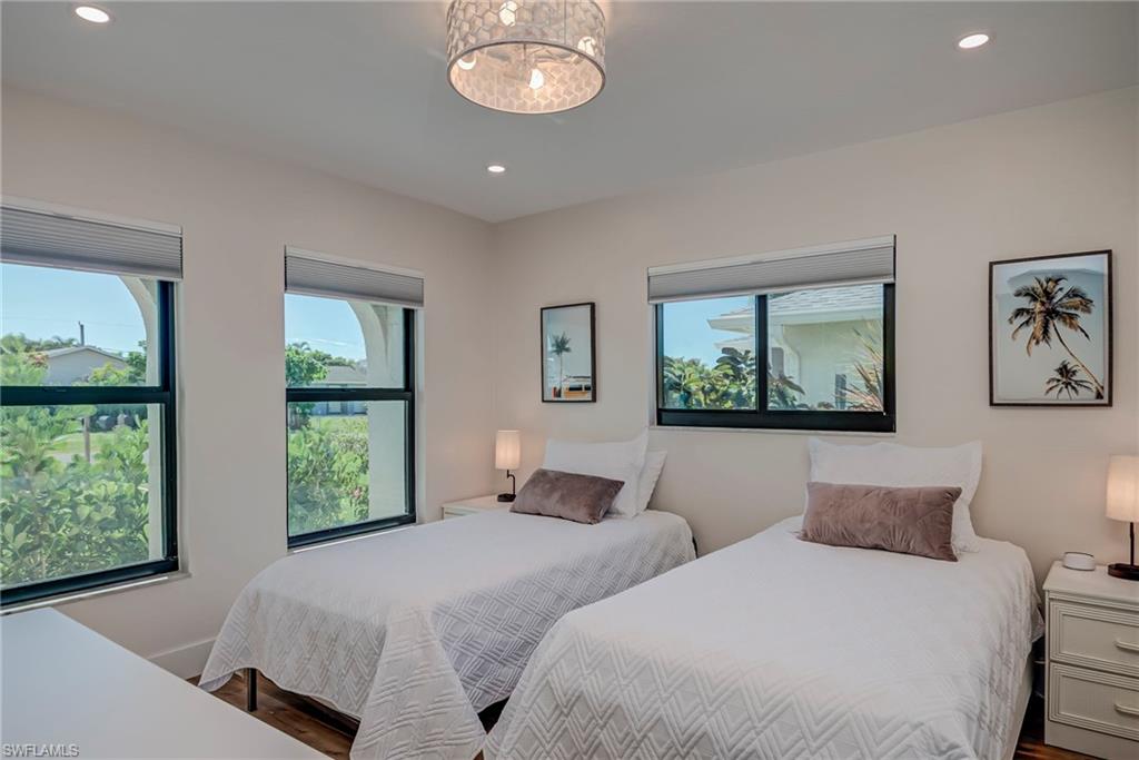 Bedroom with recessed lighting, wood finished floors, and a chandelier