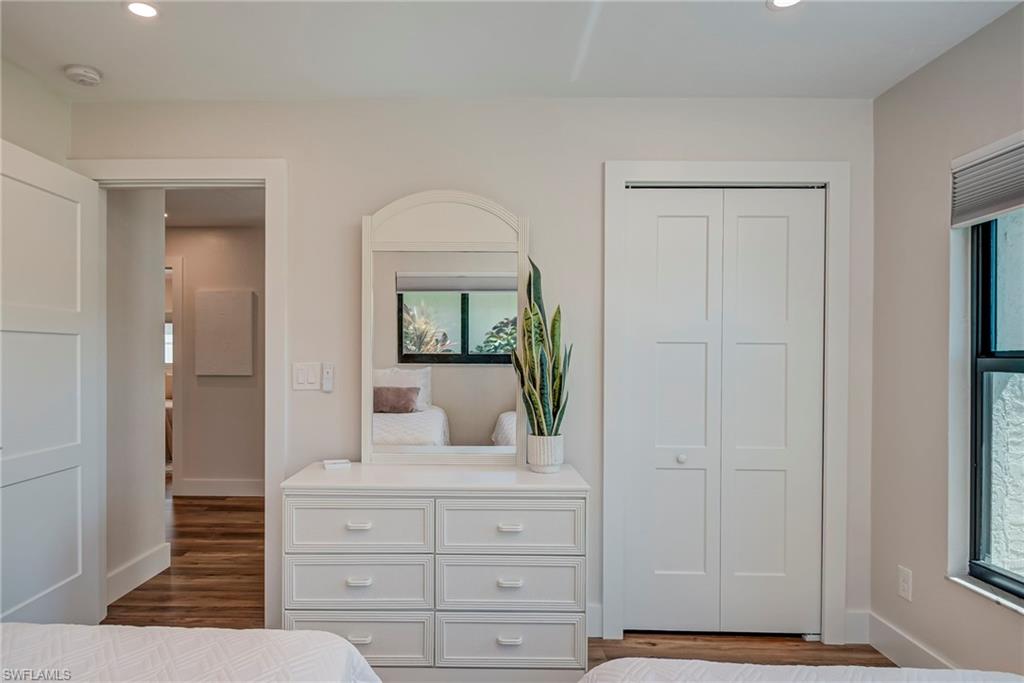 Bedroom featuring recessed lighting, dark wood-style floors, a closet, and multiple windows