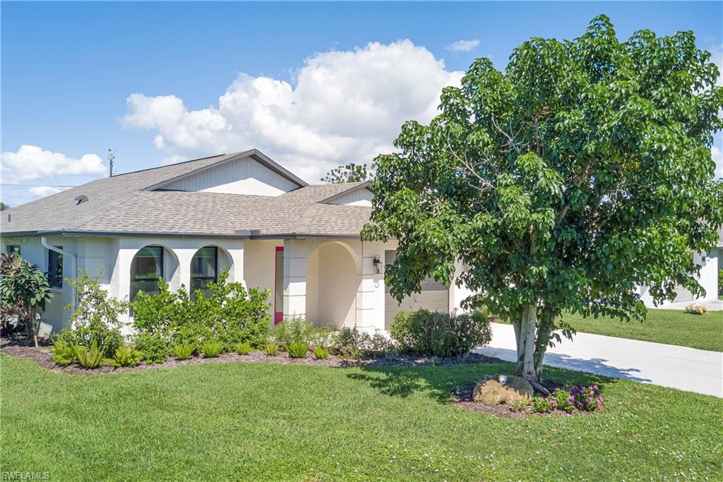 View of front of home with a shingled roof, a front lawn, driveway, and a garage