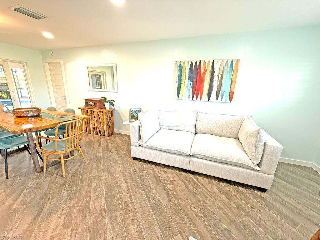 Living room with light wood-type flooring and recessed lighting