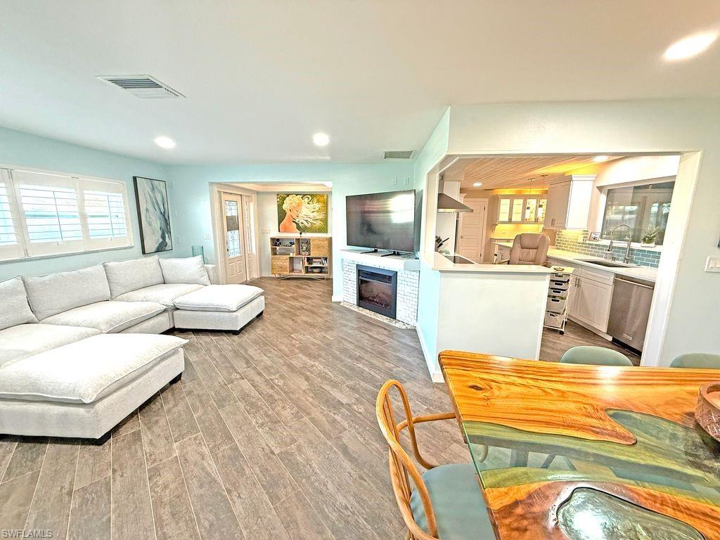 Living area featuring plenty of natural light, a fireplace, light wood finished floors, and recessed lighting