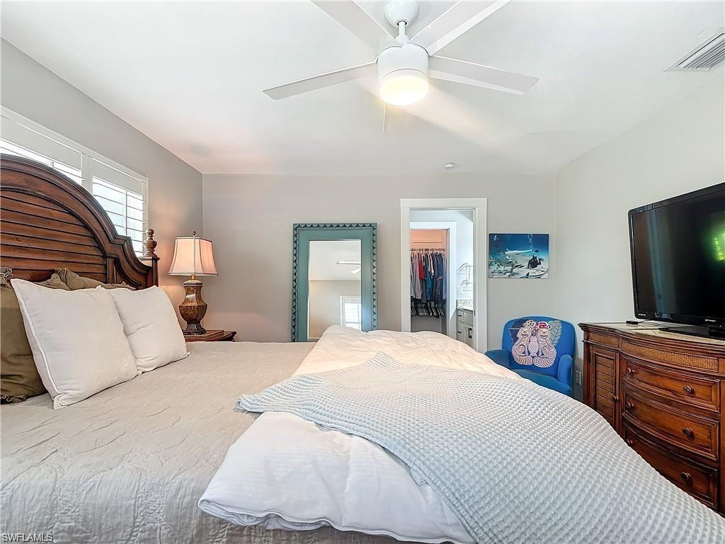 Bedroom with ceiling fan and a spacious closet