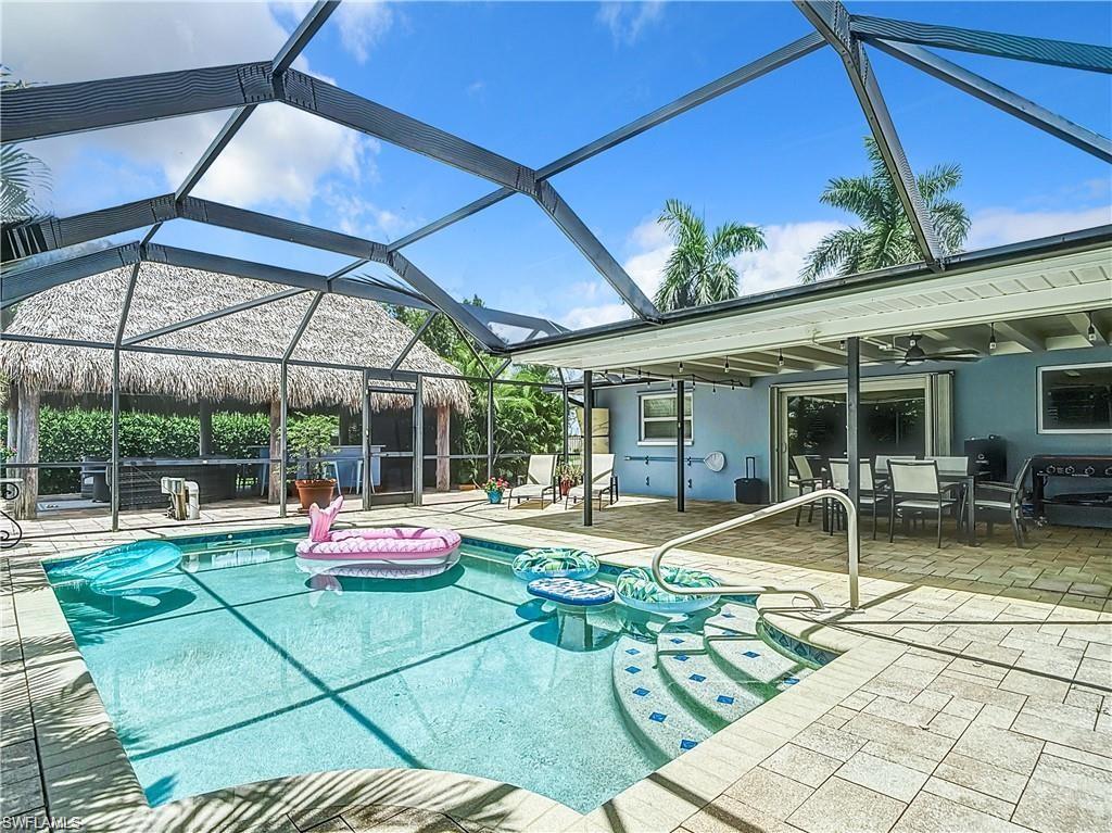 Outdoor pool featuring a sunroom, a lanai, and a patio