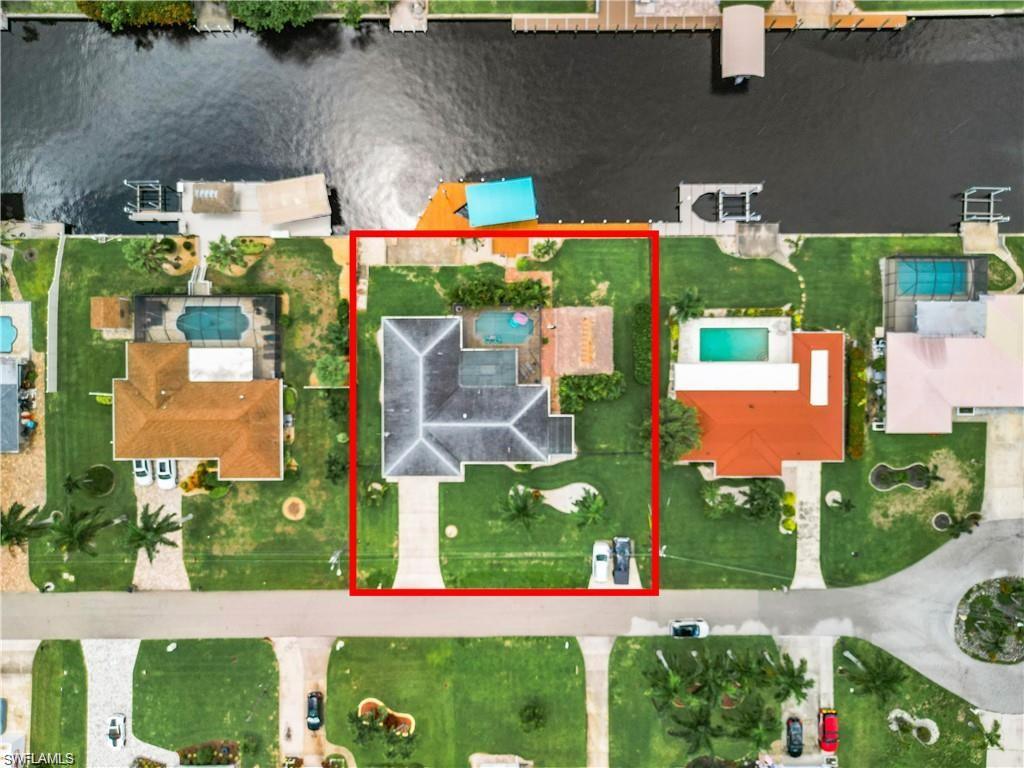 Aerial perspective of suburban area featuring a nearby body of water and property parcel outlined