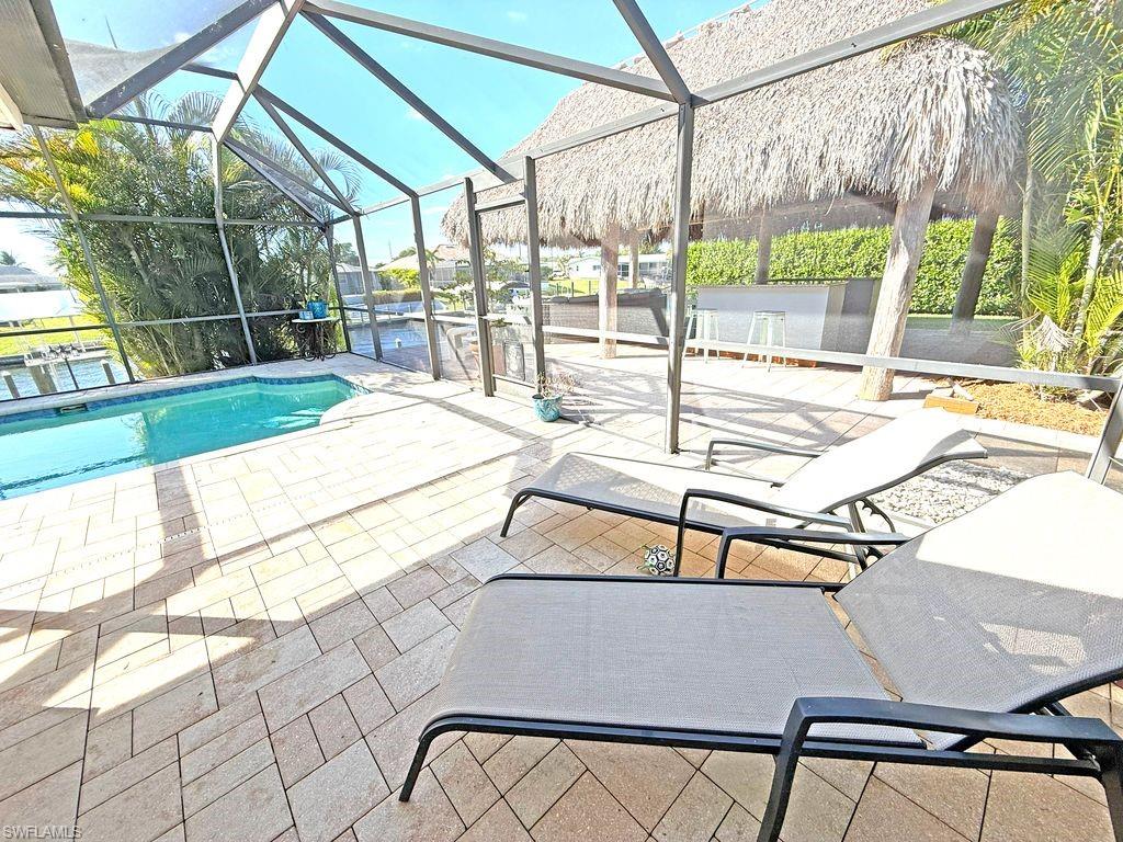 Outdoor pool featuring a patio, glass enclosure, and a sunroom