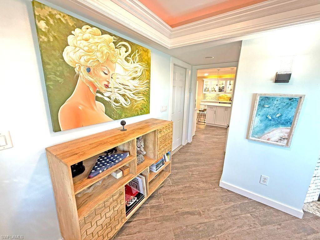 Corridor with ornamental molding and light wood-style floors