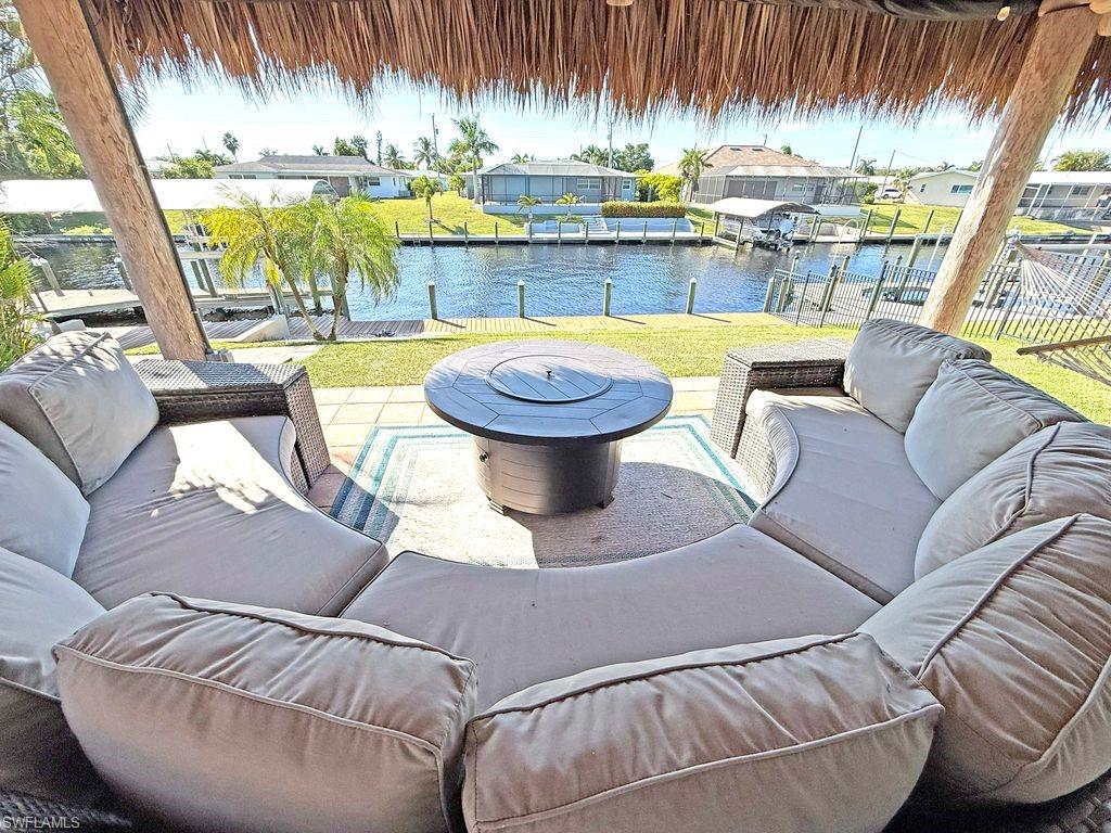 View of patio / terrace featuring an outdoor living space, a dock, a water view, and boat lift
