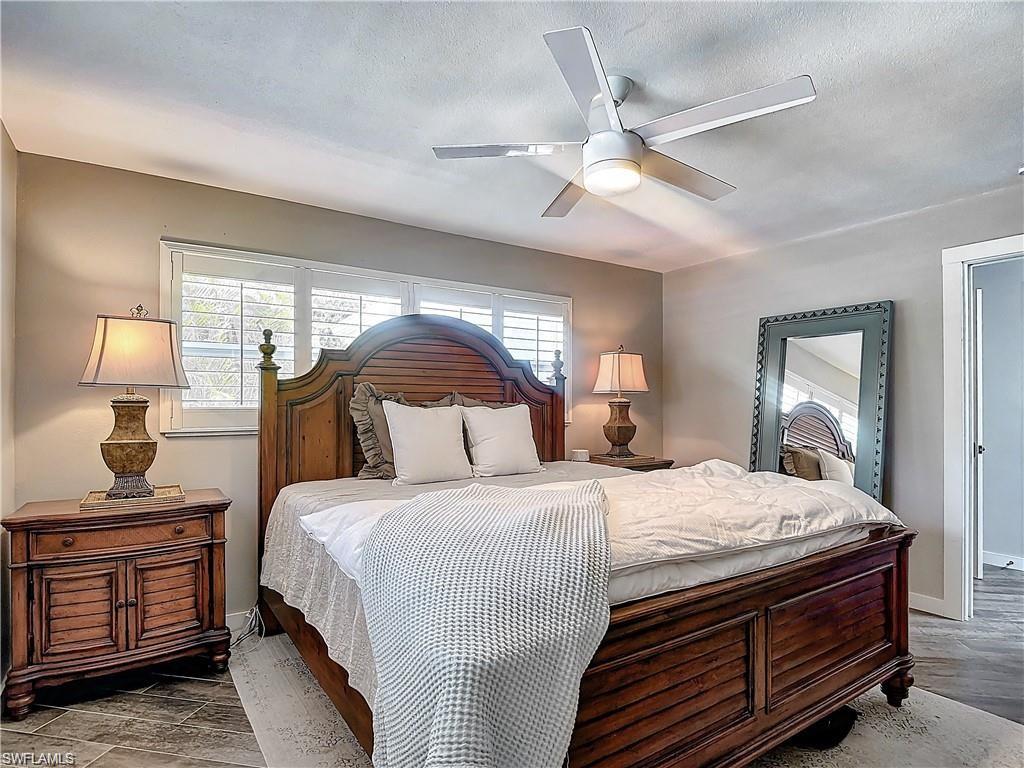 Bedroom with multiple windows, ceiling fan, and wood finished floors