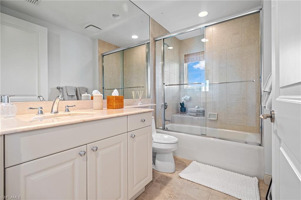 Full bathroom featuring vanity, bath / shower combo with glass door, recessed lighting, and light tile patterned floors