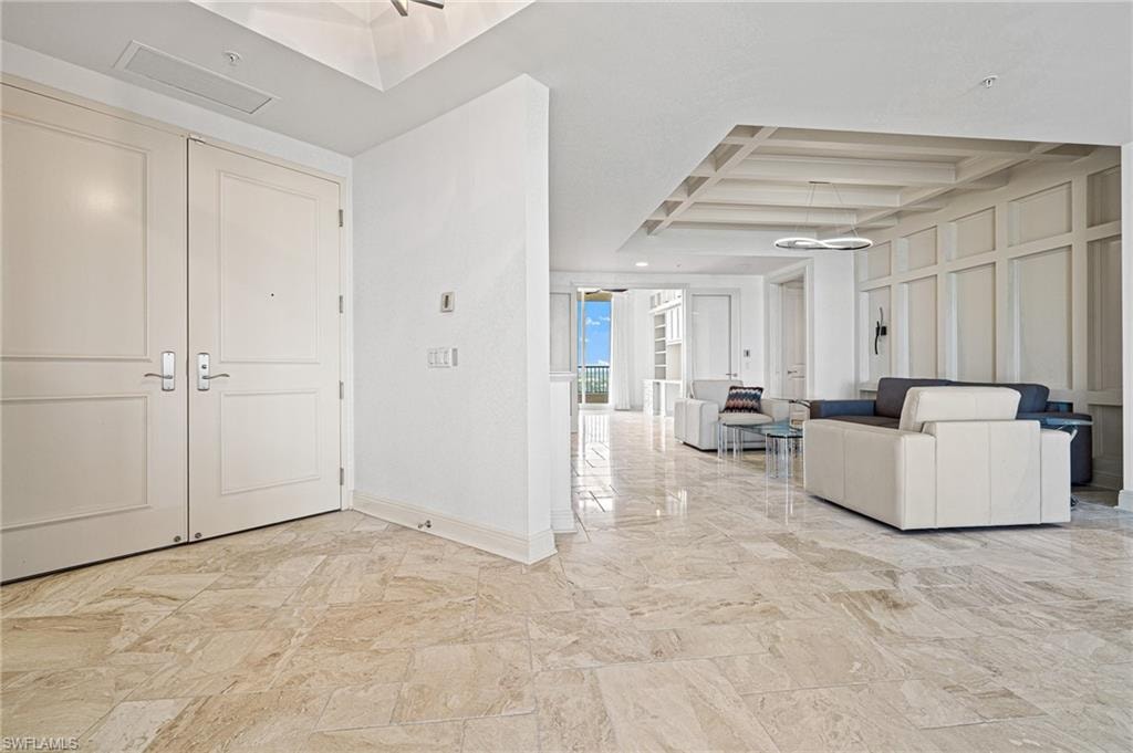 Entryway featuring coffered ceiling, beam ceiling, and a decorative wall