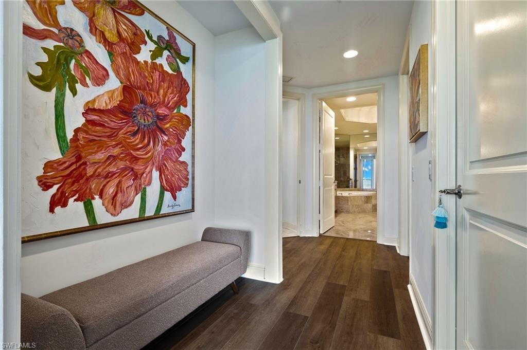 Corridor with dark wood-type flooring and recessed lighting