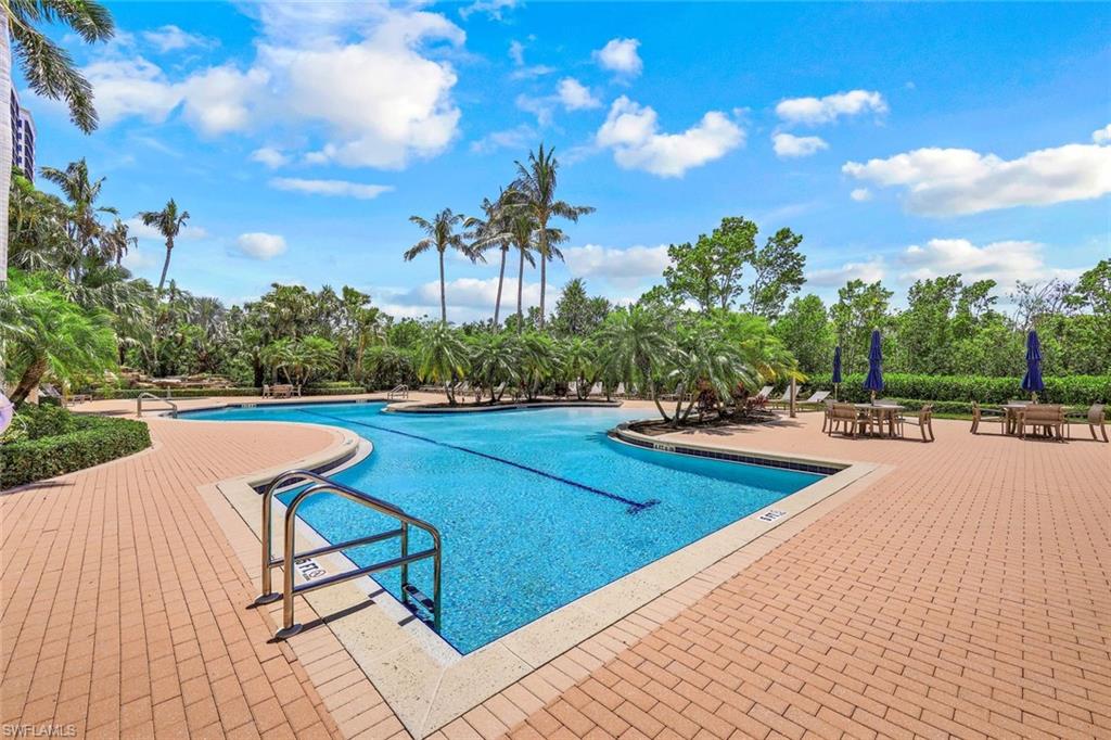 Community pool featuring a patio area and view of scattered trees