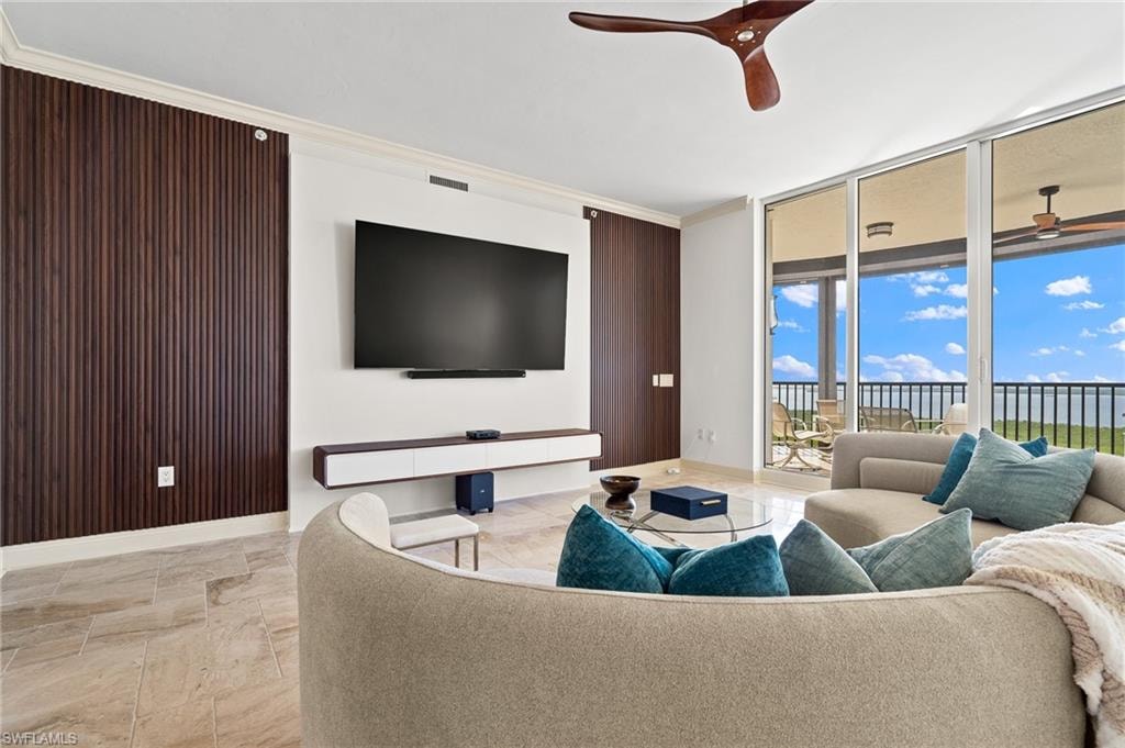 Living area with a glass covered fireplace, expansive windows, and beamed ceiling