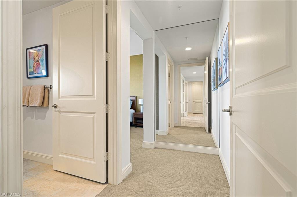 Corridor with light colored carpet and recessed lighting