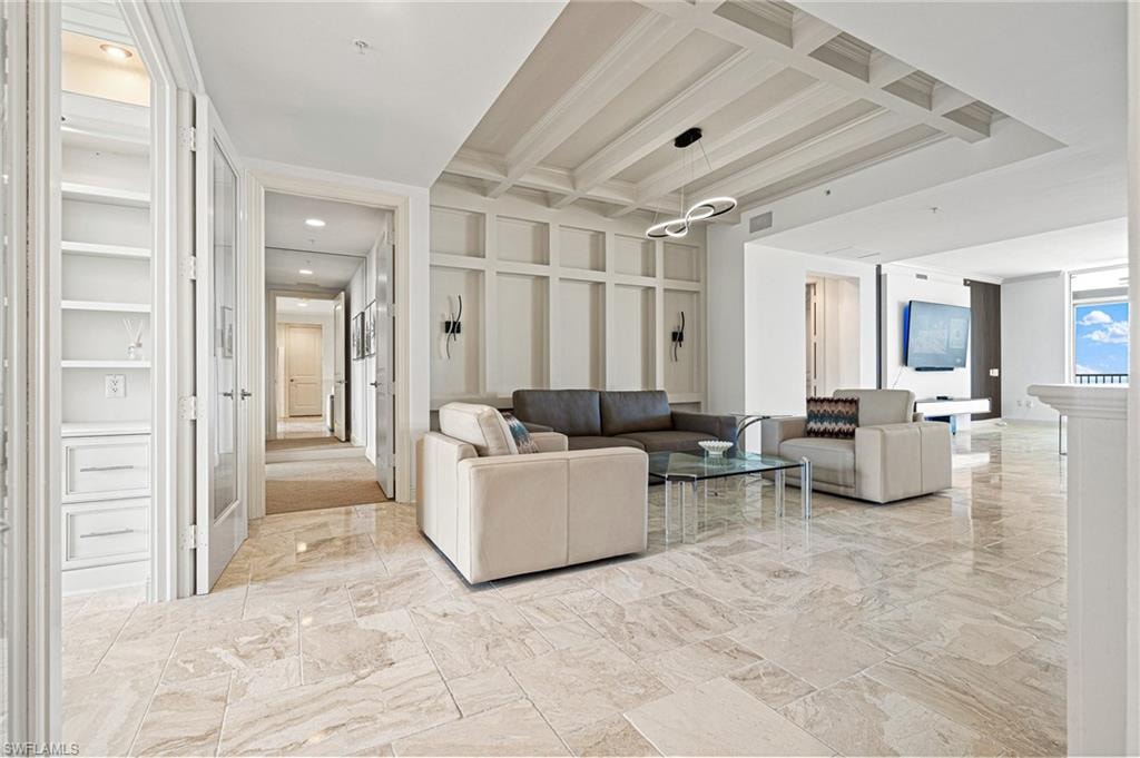 Living room with beam ceiling, a glass covered fireplace, and coffered ceiling