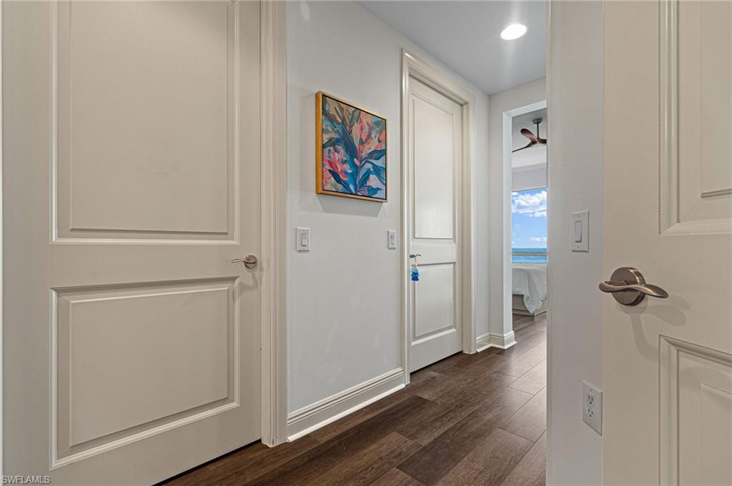 Hallway featuring dark wood-style flooring and baseboards