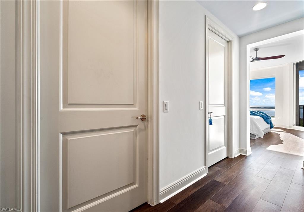 Hall with dark wood finished floors and recessed lighting