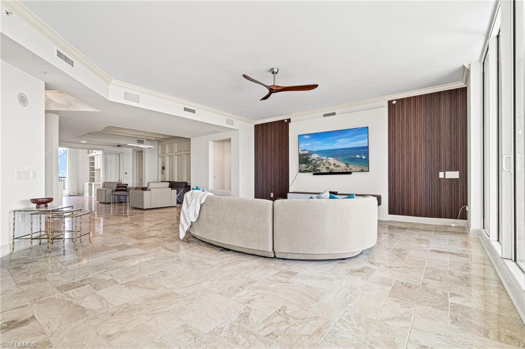 Living area featuring crown molding, a wall of windows, and a ceiling fan