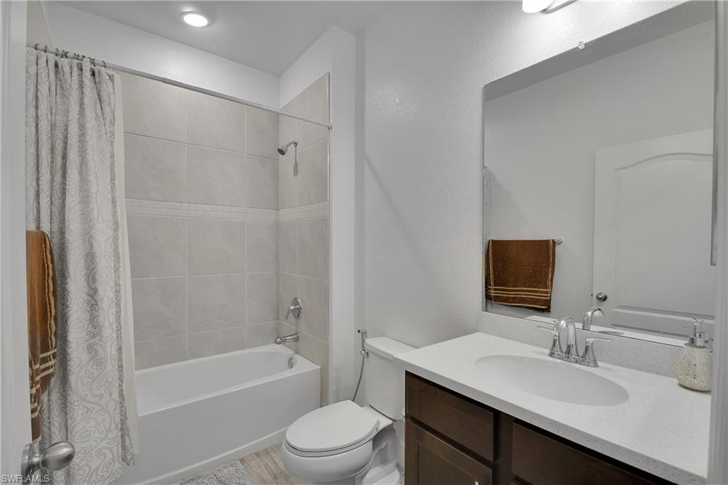 Full bath with shower / bath combination with curtain and vanity
