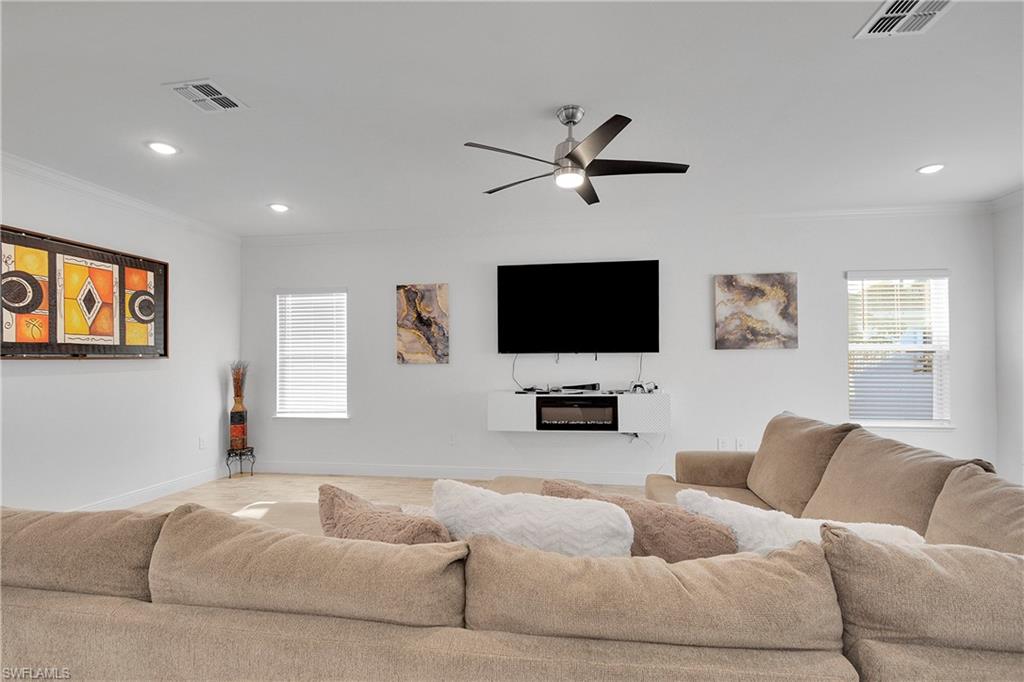 Living room featuring ornamental molding, recessed lighting, and ceiling fan