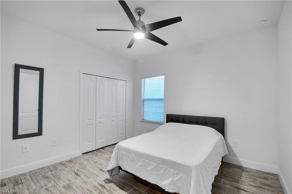 Bedroom with wood finish floors, ceiling fan, and a closet
