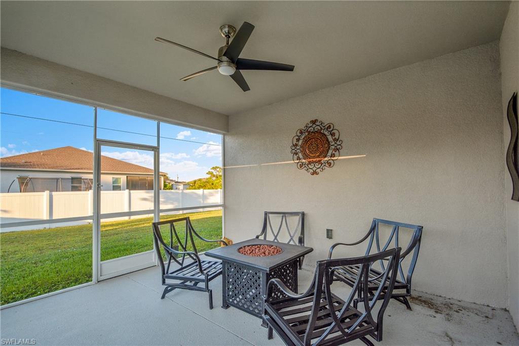 Sunroom with an outdoor fire pit, a ceiling fan, and a patio area