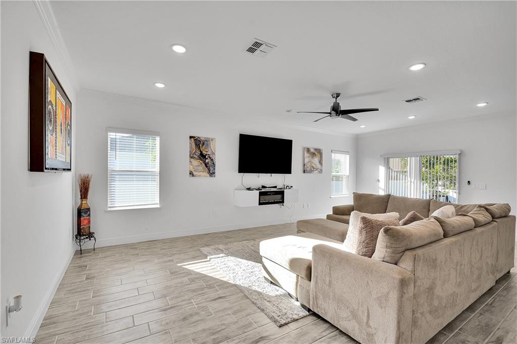 Living area with crown molding, wood tiled floors, a ceiling fan, and recessed lighting