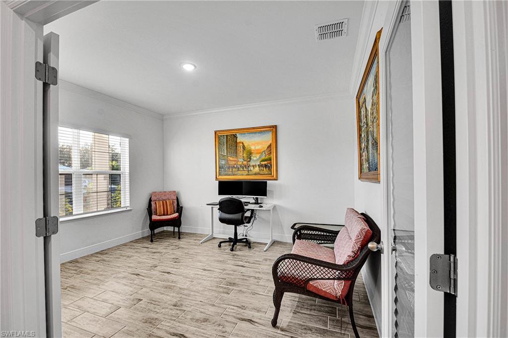 Sitting room with ornamental molding, wood finish floors, an office area, and recessed lighting