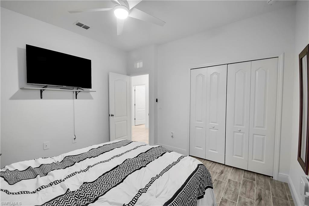 Bedroom with wood finish floors, a closet, and ceiling fan