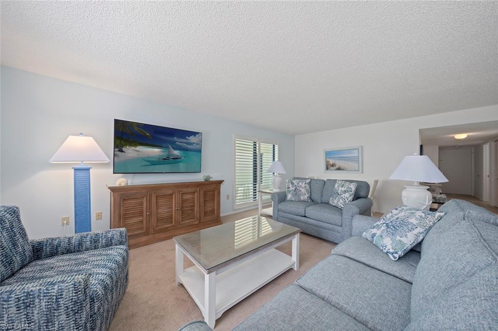 Carpeted living area featuring a textured ceiling