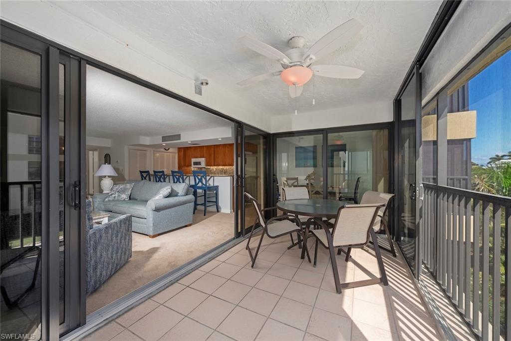 Sunroom / solarium featuring ceiling fan, outdoor dining area, and a balcony