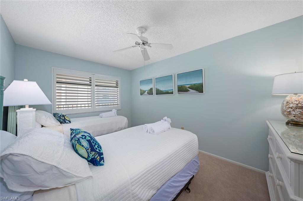 Carpeted bedroom with a textured ceiling and a ceiling fan