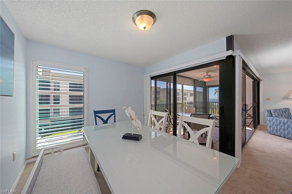 Dining area featuring light carpet and a textured ceiling