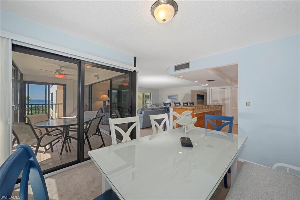 Carpeted dining space featuring a ceiling fan and a sunroom