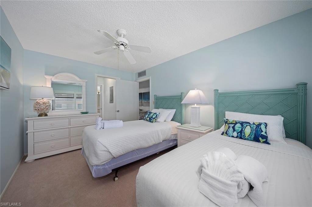 Bedroom featuring carpet, a textured ceiling, and a ceiling fan