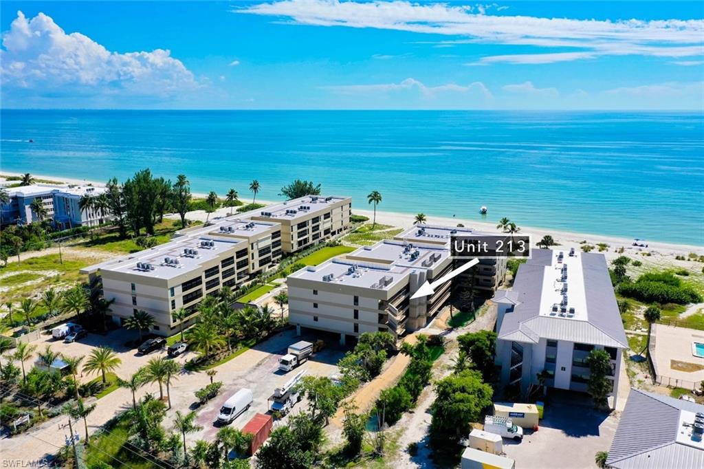 Drone / aerial view of unending shoreline and apartment complex / building