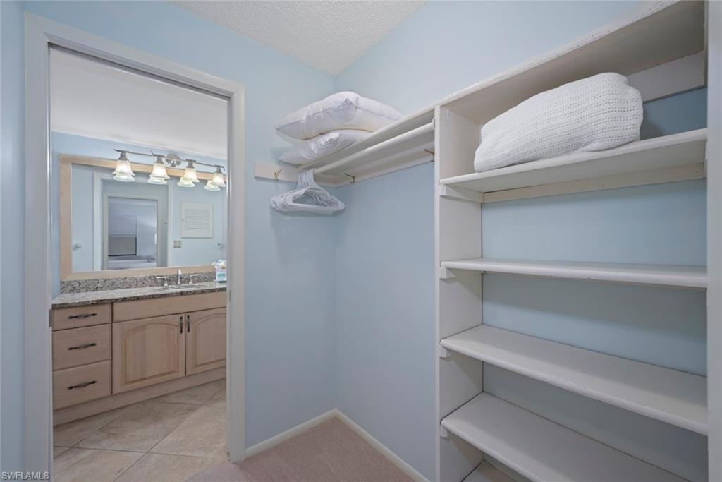 Spacious closet featuring light tile patterned floors and light colored carpet