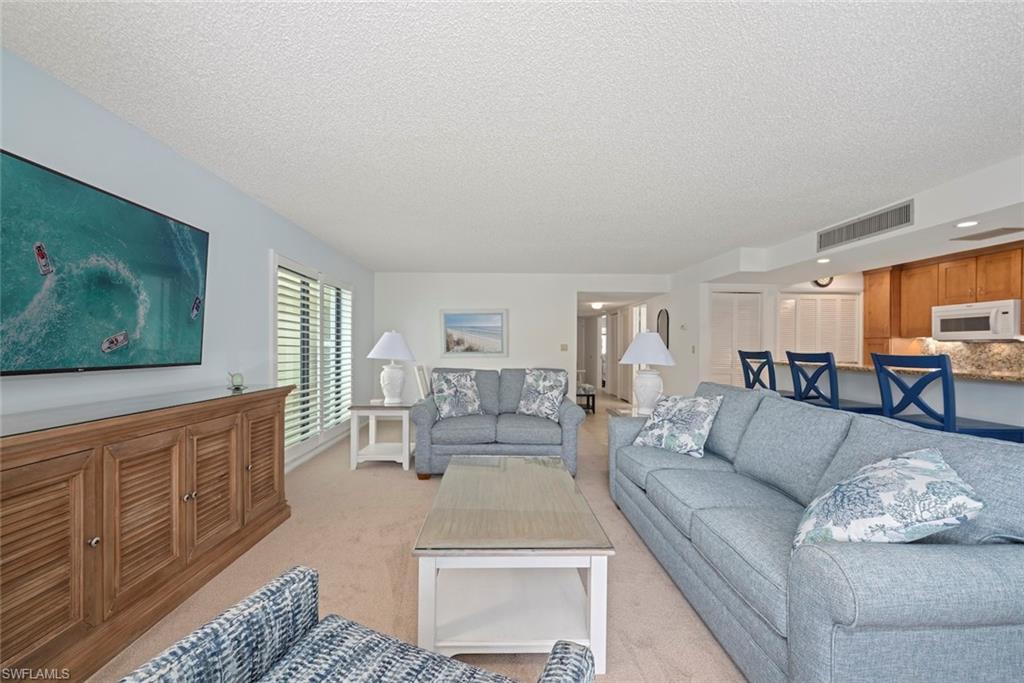 Living room with a textured ceiling and light carpet