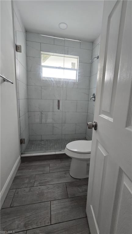 Bathroom with a shower stall and toilet