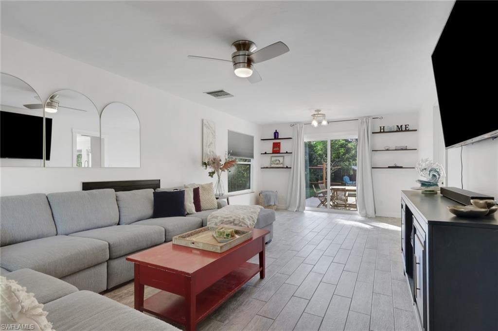 Spacious living and dining area with a real wood burning fireplace and access to the kitchen, and outdoor pool/patio area