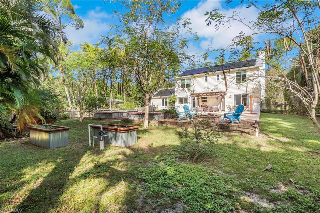 Back of the house - huge pool area and backyard space with firepit, raised garden beds, oversized chicken coop, workshop, guest house, carport, and so much more.