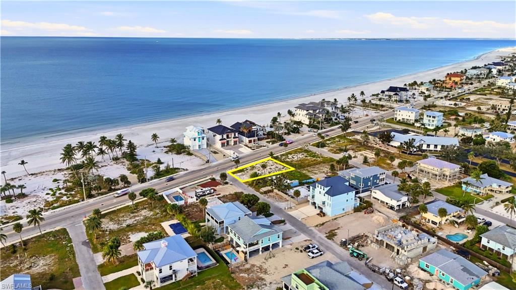 Aerial view of residential area featuring expansive beach