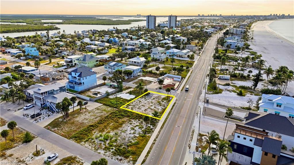 Aerial view at dusk of property boundaries highlighted, a water view, and a city view - Virtually Edited Image