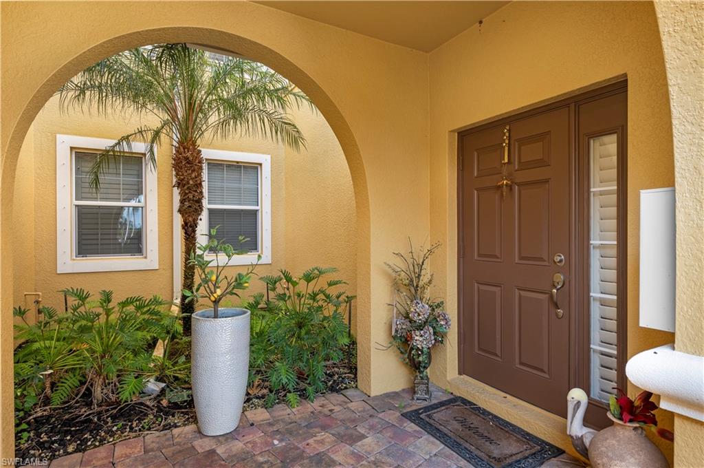 View of exterior entry with stucco siding and covered porch