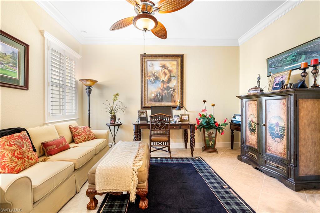 Living room featuring ornamental molding, light tile patterned floors, and a ceiling fan