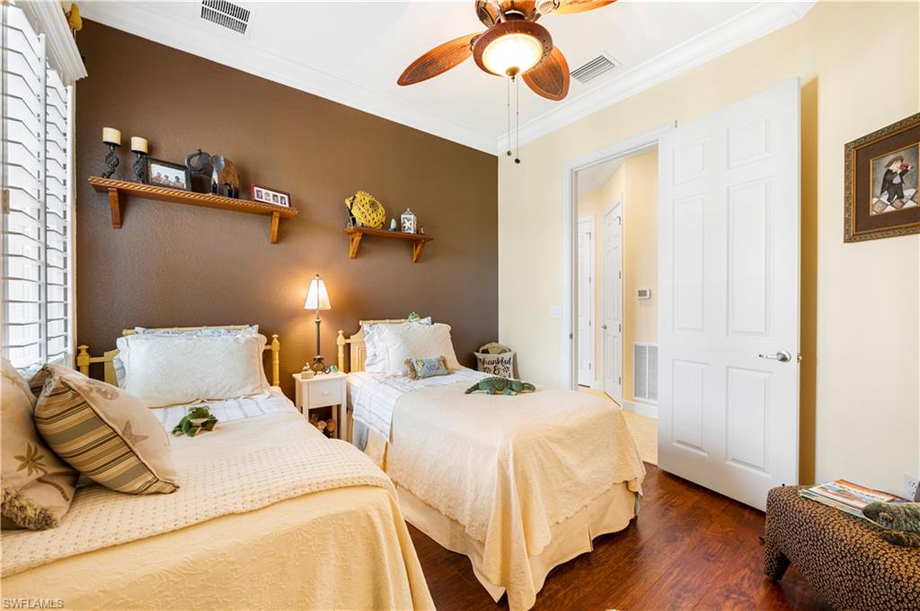 Bedroom with crown molding, wood finished floors, and ceiling fan