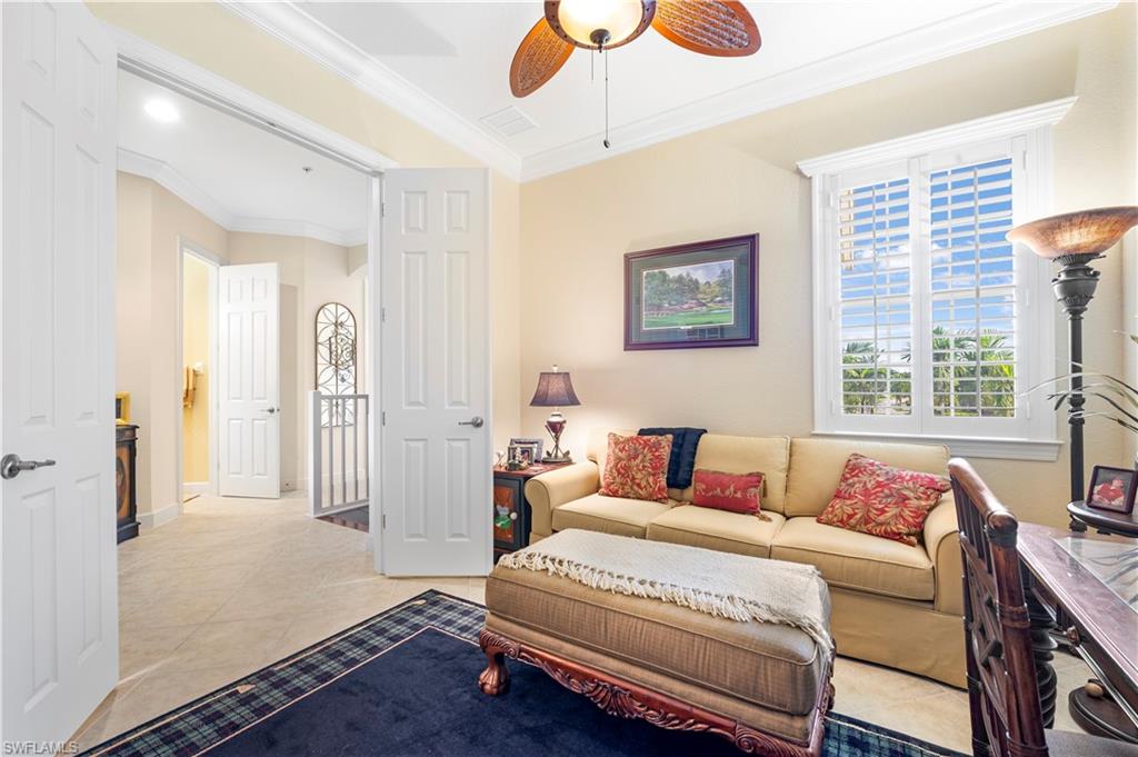 Tiled living area with crown molding and a ceiling fan