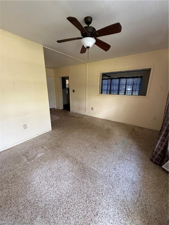 Unfurnished room with a ceiling fan and speckled floor